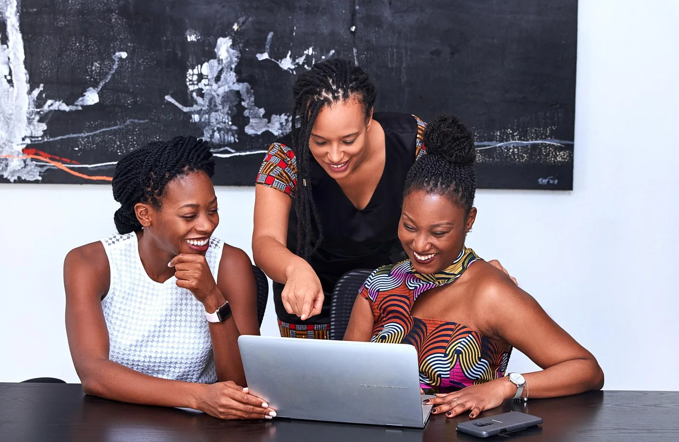 Three women working together at a laptop